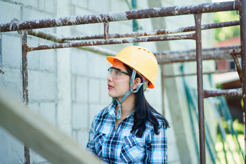 Construction worker inspecting scaffolding at job site urban environment professional portrait...