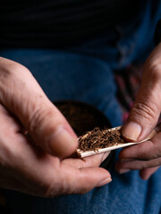 Preparing rolled cigarettes with dried tobacco.