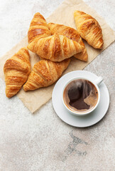 Freshly baked croissants and steaming cup of coffee creating perfect breakfast scene