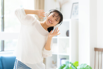 部屋で音楽を聴く若い女性