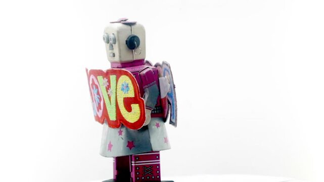 retro robot toy spinning with a message of LOVE & PEACE isolated 