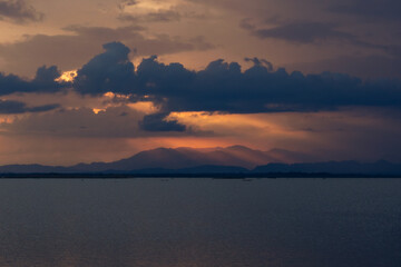 Fototapeta premium Sunset Over Mountains and Calm Water