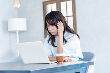 パソコンを睨む女性