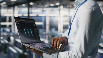 Engineer and colleague in data center reviewing large language model visualizations on laptop. IT engineering team analyze neural network performance outputs to ensure stable infrastructure operations