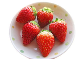Multiple hefty strawberries on a white plate