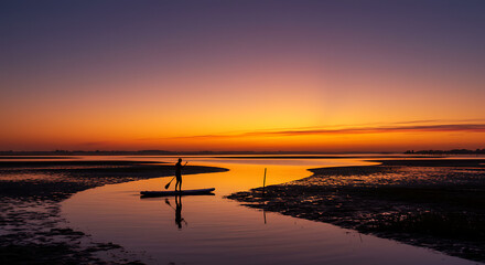 Stunning Sunset Silhouette of Paddleboarder on Calm Bay Waters