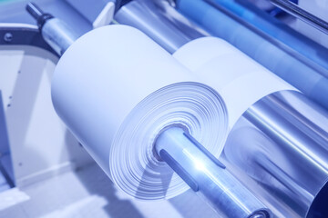 Roll of polyethylene film for bags and packaging. Extrusion line for the production of polyethylene film for products packaging. Winding a polyethylene roll for packaging