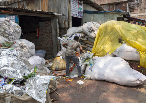 Bangladeshi man dismantling plastic bags for recycling, Dhaka Division, Dhaka, Bangladesh