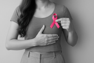 breast cancer awareness: A woman holding a pink ribbon in her hands, symbolizing support for breast cancer awareness and the importance of spreading awareness for early detection and prevention