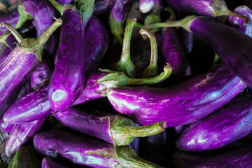 A close-up photo of a pile of purple eggplant or aubergine.