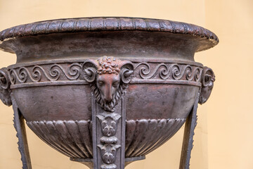 Antique iron vase with ornaments and animals in close-up.