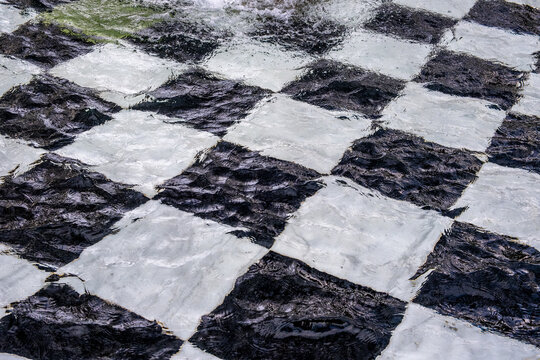Diamond-shaped black and white tile at the bottom of the fountain under water.