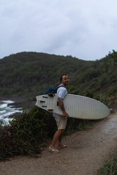 Man walks towards the beach with a surfboard