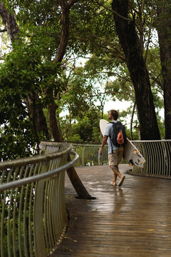 Young man carrying surfboard and walking to beach