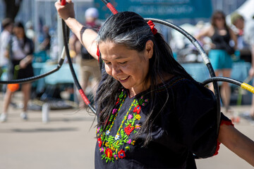 Smiling hoop dancer finishes a spring festival demo to a warm crowd.