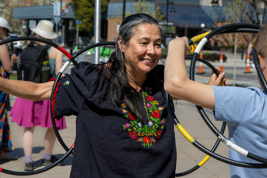 An Indigenous woman connects with a child during a hoop dance demo.