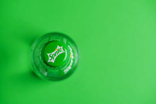 Lviv, Ukraine - May 25, 2025: Close-up cap of Sprite glass bottle on green background. Top view