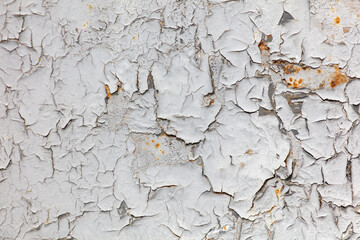 The wall is covered in peeling paint and has a rough texture