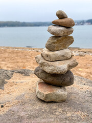 Stacked stones on a tranquil lake shore, symbolizing balance, peace, and connection with nature