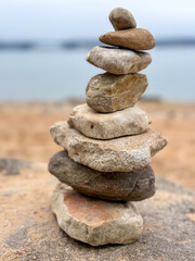 Stacked stones on a tranquil lake shore, symbolizing balance, peace, and connection with nature