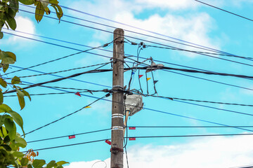 Portrait of towers, streetlights, and power poles with conduit cables on an isolated blue sky...