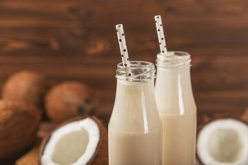 Bottle of delicious fresh coconut milk on textured background. Coconut yogurt with coconut on table. Vegan eco friendly product. Space for text.Copy space.