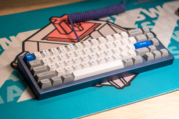 Custom mechanical keyboard on themed desk mat with coiled cable