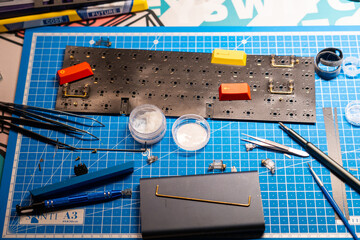 Mechanical keyboard building workspace with tools and PCB