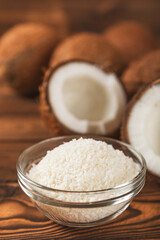Set of fresh whole and half coconuts and slices on wooden background. Coconut flakes. Vegan....