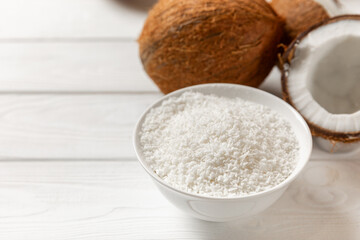 Set of fresh whole and half coconuts and slices on wooden background. Coconut flakes. Vegan....