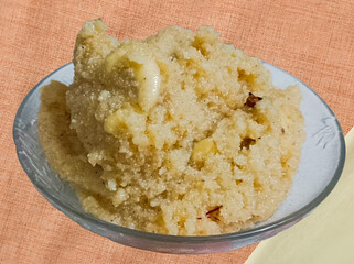 A warm bowl of Suji ka Halwa, a classic Indian dessert made from semolina, ghee, and sugar, garnished with almonds and dried fruits—perfect for festive celebrations.