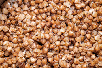 Plate with tasty buckwheat porridg.Boiled buckwheat porridge in ceramic pot on wooden background.