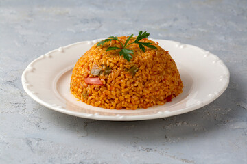 Traditional turkish bulgur pilaf with tomato sause in plate (Turkish name; meyhane pilavi)
