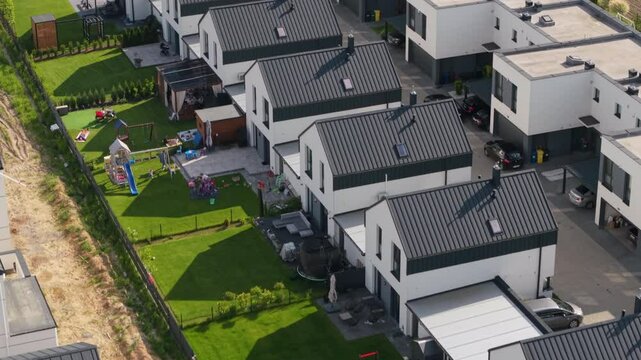 Aerial view of newly built passive houses on the outskirts of a large city, where real estate market trends, shifting demographics, and credit availability are driving demand for property.