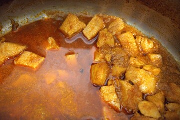 Chicken stew in cooking pan close up.