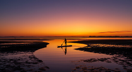 Serene Sunset Paddleboarding Silhouette of Person on SUP Board at Calm Bay during Vibrant Golden