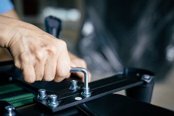 Close-up of a woman's hand using a tool to tighten a nut