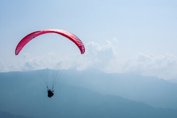 Para-glider Soaring Above Scenic Landscape Under Clear Blue Sky