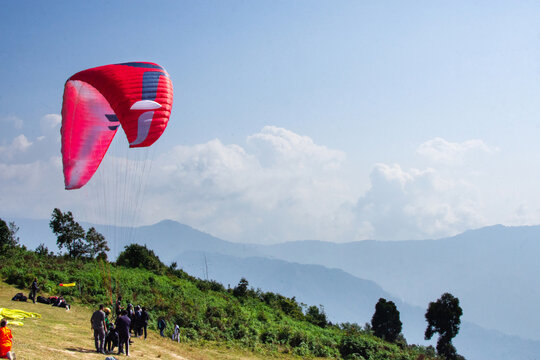 Para-glider Soaring Above Scenic Landscape Under Clear Blue Sky