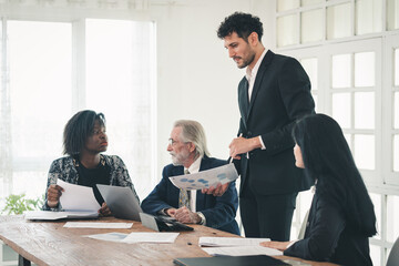 Group of multiethnic businessman entrepreneur and senior manager male conference in meeting room at workplace, employees brainstorming discussing business strategy planning using laptop technology