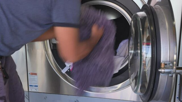 Adding clothes to the industrial washing machine