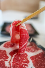 Use wooden chopsticks pick up raw beef