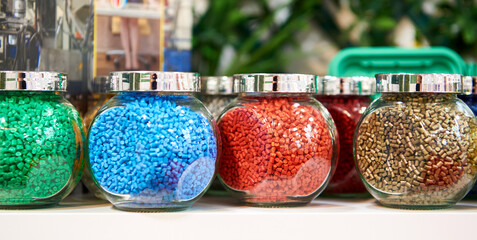 Glass jars with samples of plastic colored granules