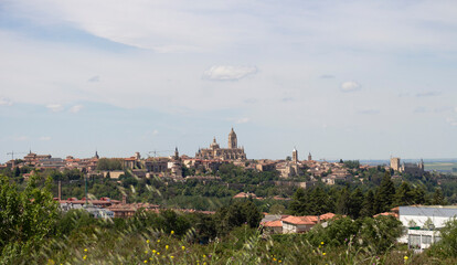 Fototapeta premium Segovia Cathedral rising above the cityscape under cloudy sky in Spring