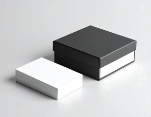 A black box and a stack of blank white cards on a grey surface