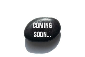 Coming soon message written on black stone on white background. Conceptual coming soon symbol. Copy...