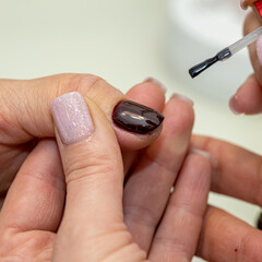 Nail care procedure in a beauty salon. Female hands and tools for manicure, process of performing manicure in beauty salon. Concept spa body care. Gloved hands of a skilled manicurist cutting cuticles