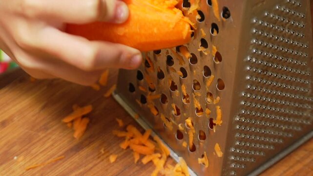 Carrot Grating Kitchen: Hands Grate Carrot on Box Grater for Cooking