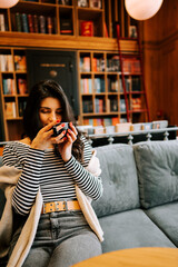 Woman enjoying a warm drink in a cozy library cafe during a calm afternoon