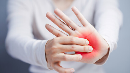 Female hand showing palm pain with red inflammation zone as symptom of arthritis or carpal tunnel syndrome discomfort